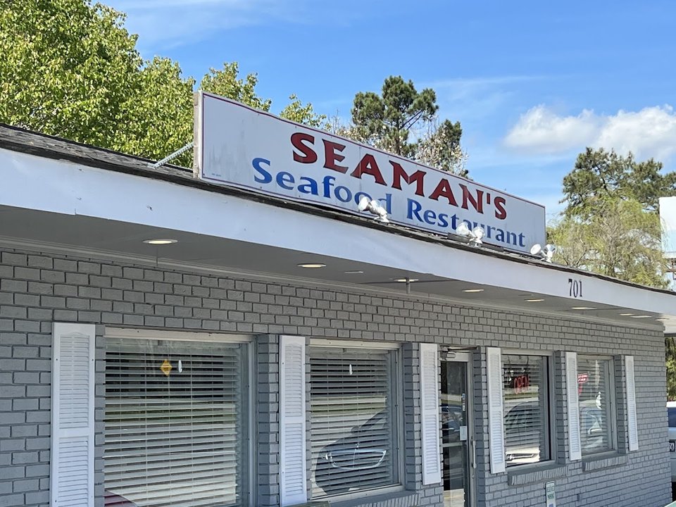 Seafood restaurant interior with simple tables and chairs.